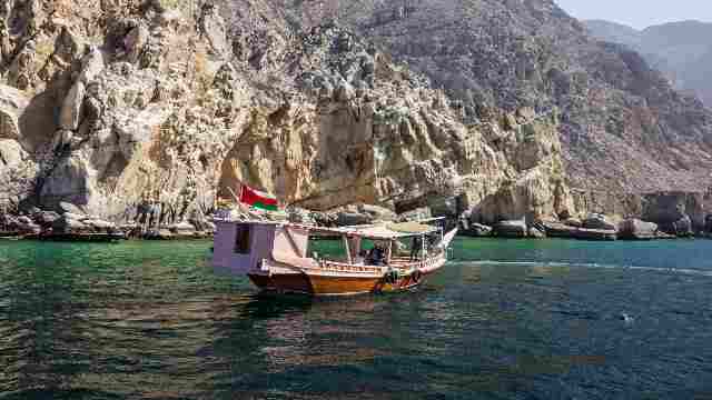 Dolphins-and-tourist-dhow-boats-Oman-by-travelstoyou