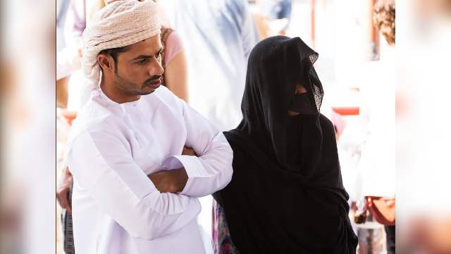 Exploring Captivating Traditions and Tours in Salalah 13 Oman-Omani-couple-in-traditional-clothes-with-a-woman-wearing-a-veil-and-a-mask-at-the-Friday-market